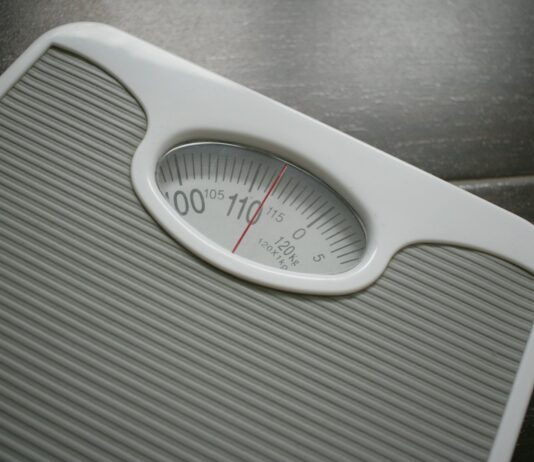 다이어트와 운동: 몸과 마음을 위한 긍정적인 변화 a bathroom scale sitting on top of a wooden table