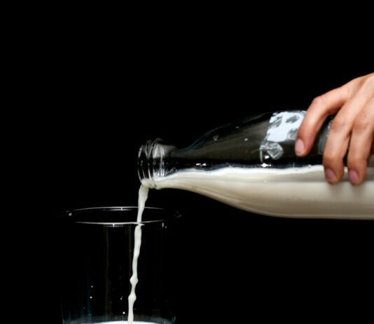 건강한 뼈를 위한 칼슘과 비타민 D person pouring milk on clear drinking glass