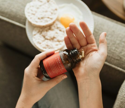 프로바이오틱스, 당신의 장은 건강하신가요? person holding red bottle