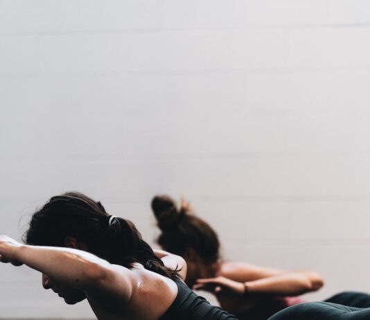 하루 10분, 필라테스로 허리 통증 잡는다 woman in black tank top and black leggings lying on black floor