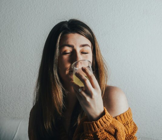 “마음챙김 식사로 건강도 챙기고 다이어트 효과까지” a woman drinking a glass of water on a couch