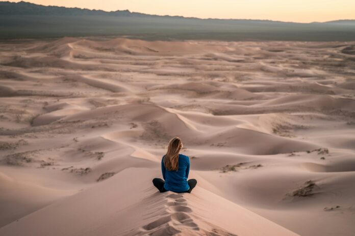 Photo by Patrick Schneider woman sitting on sand field
