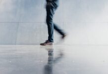 “하루 1만 보 걷기, 정말 효과있을까? 한국인에게 맞는 걷기 습관 찾기” person wearing blue denim jeans beside gray wall
