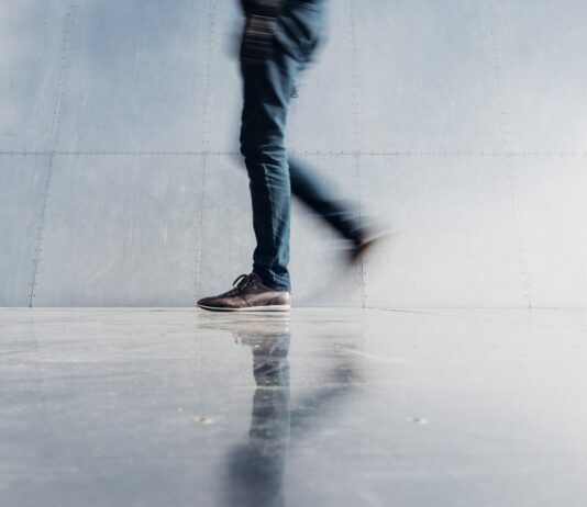 “하루 1만 보 걷기, 정말 효과있을까? 한국인에게 맞는 걷기 습관 찾기” person wearing blue denim jeans beside gray wall
