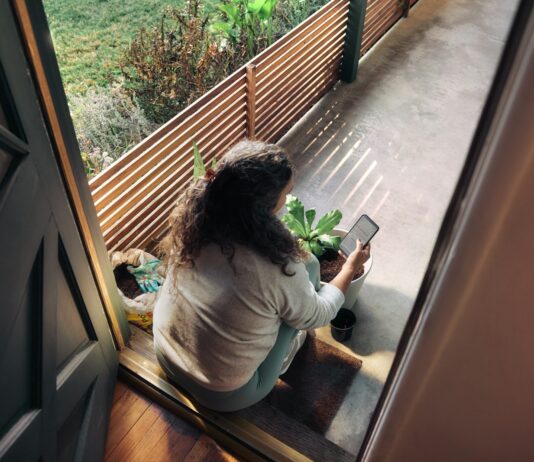 만성피로, 생활 습관 바꾸기로 ‘탈출’ 가능할까? Woman sitting on balcony with smartphone