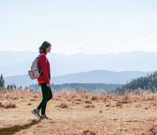 “걷기, 일상 속 작은 변화로 건강 지키기… 최신 워킹 트렌드와 실천법” a man with a backpack walking across a dry grass covered field